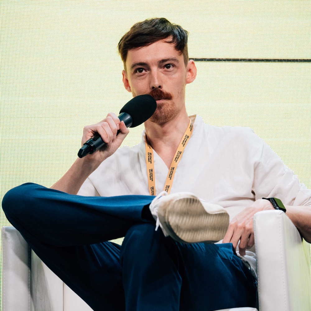 Peter speaking on stage at Urban Tech Forward, holding a microphone